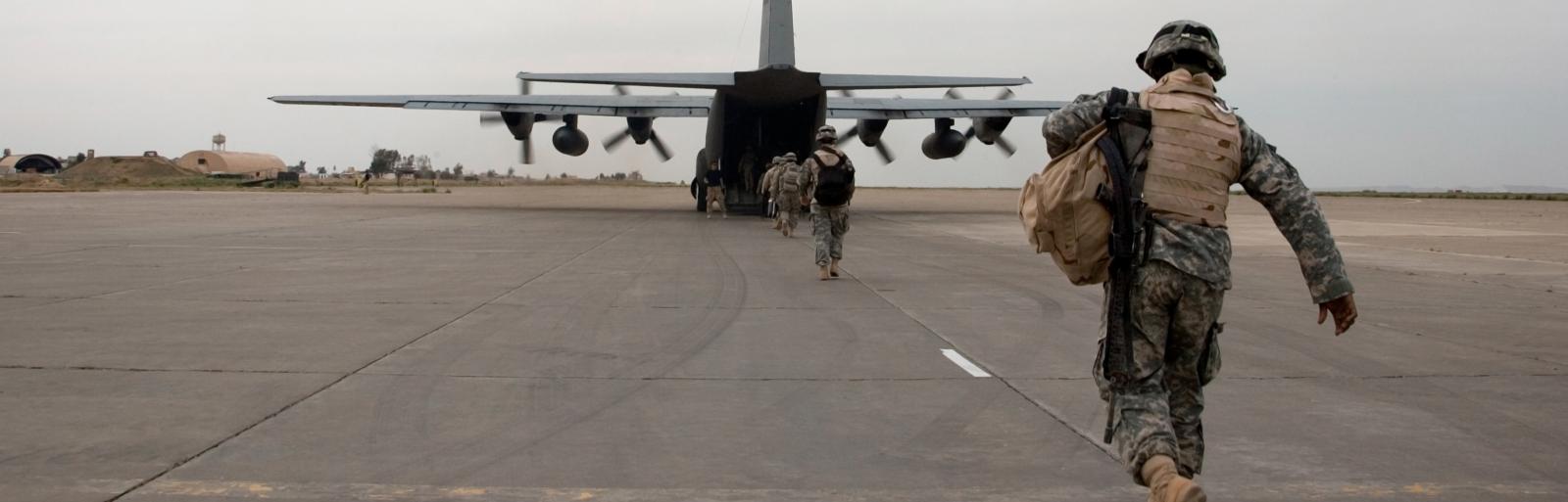 soldiers getting on a plane on the runway