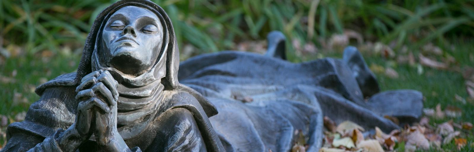 statue nun praying on lawn at Creighton University